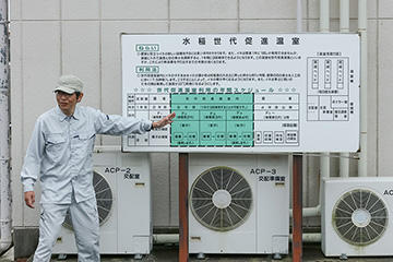 「水稲世代促進温室」について説明する、栽培研究部 水稲育種係の日野耕作さん